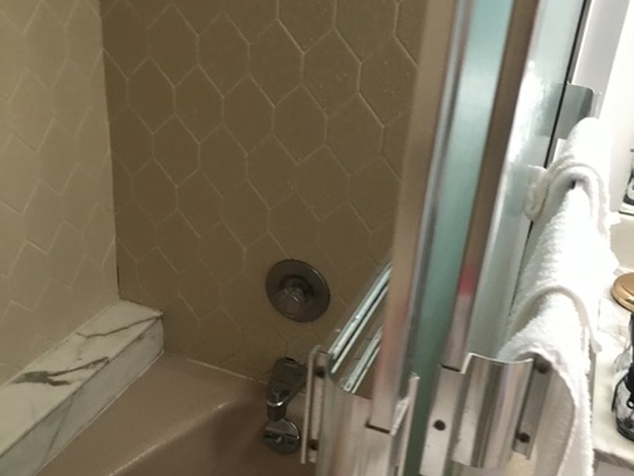 Bathroom with old tub and dated tile before remodeling