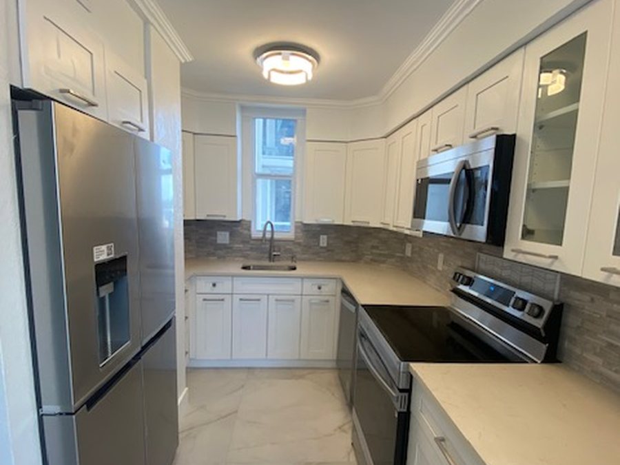 Remodeled white kitchen with new sink and plumbing connections by Fontana Plumbing