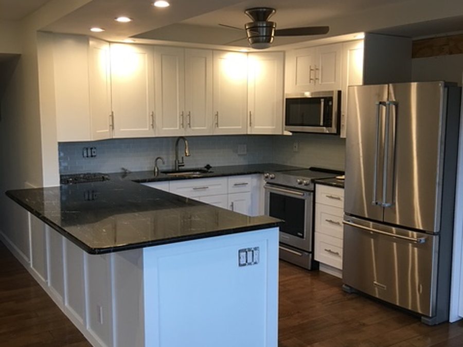 Kitchen remodel with dark granite counters and new sink plumbing by Fontana Plumbing